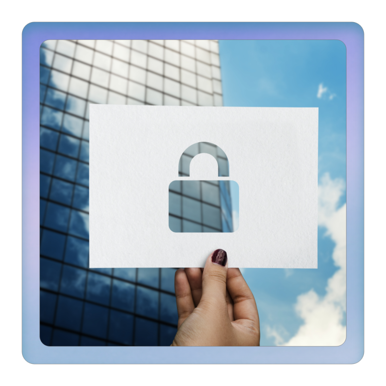 Eine Hand hält ein Blatt Papier mit einem Schloss-Symbol vor einem modernen Gebäude.